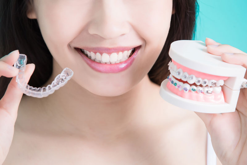 an invisalign patient holding a tray of invisalign