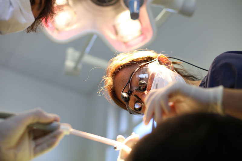 Dentist Performing A Gum Recession Treatment Procedure